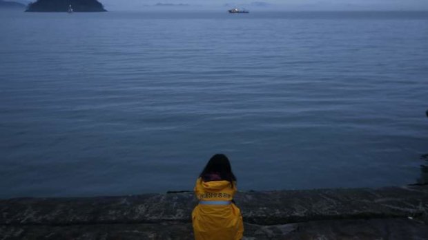 Waiting on the waves: A family member of missing passengers pays vigil onshore.
