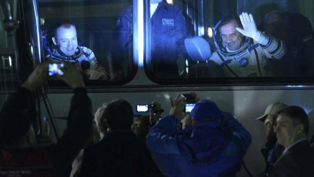 The International Space Station crew members Russian cosmonauts Pavel Vinogradov (right) and Alexander Misurkin wave from a bus after donning space suits.