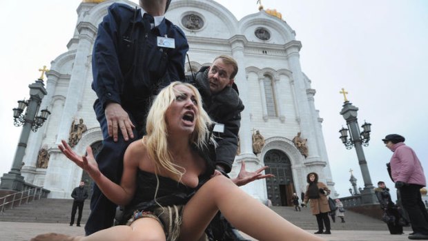 Police move in on an election protester in front of the Christ the Saviour Cathedral in Moscow.