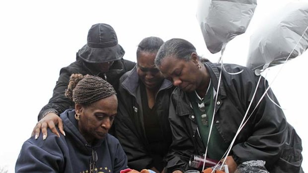 Angela Gilliam (L), aunt of Lashanda Armstrong, holds a vigil.
