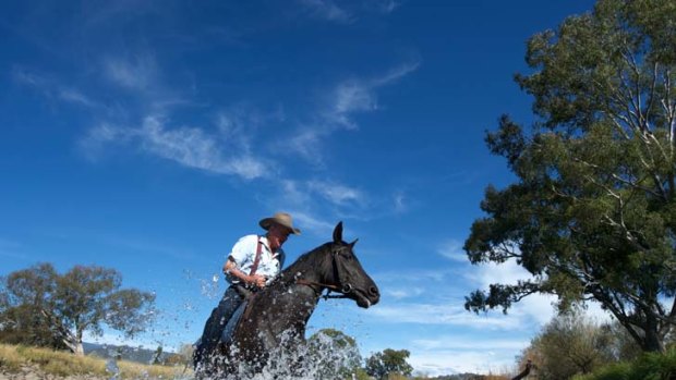 At home in his saddle ... stockman Kevin Goldsworthy, who works on Towong Hill Station, crosses the Murray. A decade ago, with the Hume Dam shrunken, it was a muddy trickle of a river.