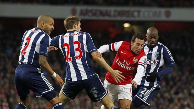 Arsenal's Spanish midfielder Santi Cazorla (second right) is tackled by West Bromwich Albion's Northern Irish defender Gareth McAuley (second left).