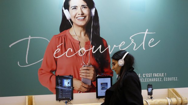 A woman listens with headphones to an audiobook during a visit to the Paris International Book Fair, held at the Porte de Versailles in Paris, France, in March.