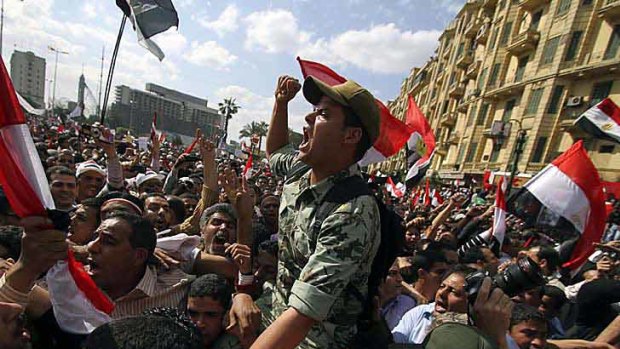 An Egyptian army officer is carried on demonstrators’ shoulders.