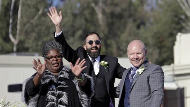 Reverend Alfreda Lanoix, left, with grooms Danny Leclair and Aubrey Loots after their marriage during the Tournament of Roses Parade.