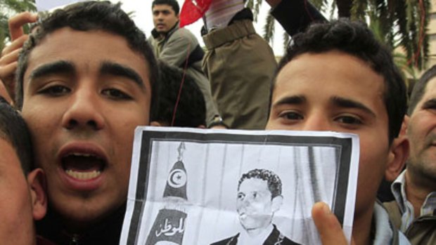 No longer a victim ... protesters in Tunis with a picture of Bouazizi.