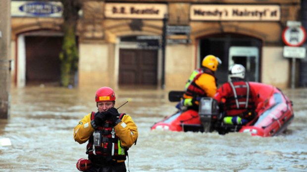 Wet work: Emergency workers in the flooded English town of Cockermouth. About 200 people had to be rescued and about 1000 homes were flooded.