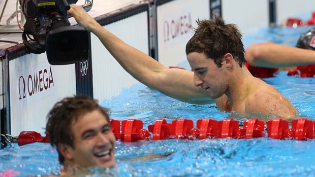 Came in second ... James Magnussen looks disappointed as winner Nathan Adrian celebrates victory in the 100m freestyle.