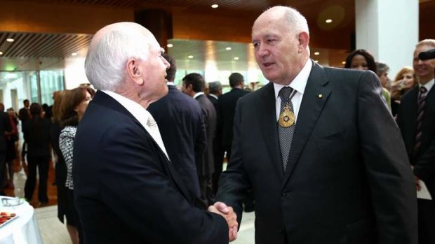 Former prime minister John Howard greets Sir Peter at the ceremony.