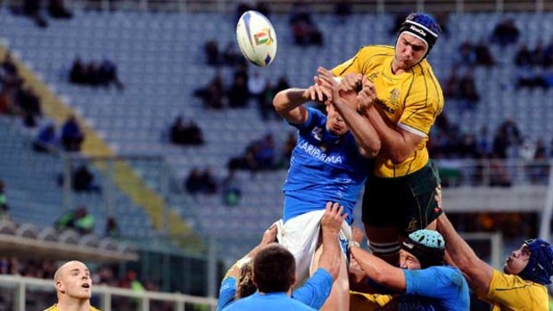 Australia's Rob Simmons tussles with Italy's Luciano Orquera in Florence.