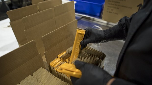 An employee packs Kiva Confections cannabis-infused chocolate into boxes at the company's headquarters in Oakland, California.