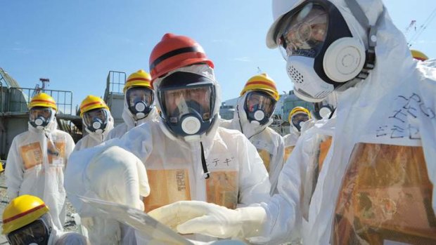 Japan's Economy, Trade and Industry Minister Toshimitsu Motegi (centre), wearing a protective suit and a mask, inspects at the tsunami-crippled Fukushima Daiichi nuclear power plant.