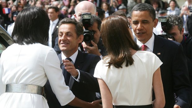 President Barack Obama (right) and Michelle Obama (left) are welcomed by French President Nicolas Sarkozy (second left) and Carla Bruni-Sarkozy in Normandy. 