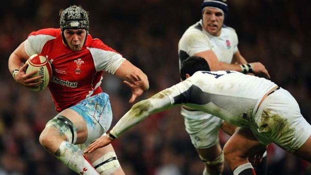 Dan Lydiate of Wales attempts to evade the tackle by England's centre Shontayne Hape.