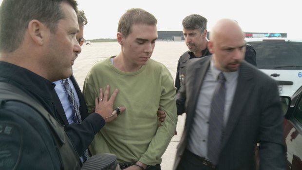 Luka Magnotta, centre, escorted by police upon arrival in Canada from Germany in 2012, seen in a police photo.