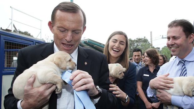 Tony Abbott, with daughter Frances, holds a puppy at Victoria Guide Dogs the day before the election.