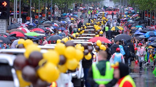 Thousands brave wet conditions for the annual Grand Final parade through Melbourne streets.