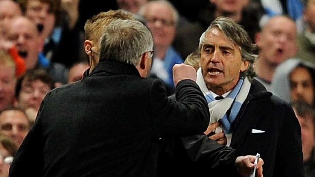 Manchester United Manager Sir Alex Ferguson clashes with Manchester City Manager Roberto Mancini (R).