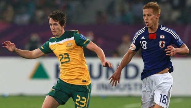 Robbie Kruse is chased by Keisuke Honda during the Asian Cup final.
