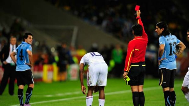 Down to 10 men ... Uruguay's Nicolas Lodeiro, left, trudges off after being shown the first red card of the 2010 World Cup.