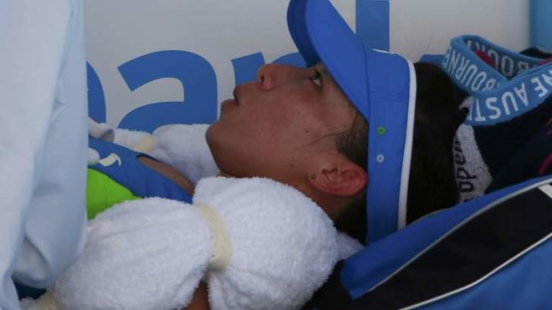By degrees: China’s Zheng Jie takes a medical time-out during her loss to Casey Dellacqua.