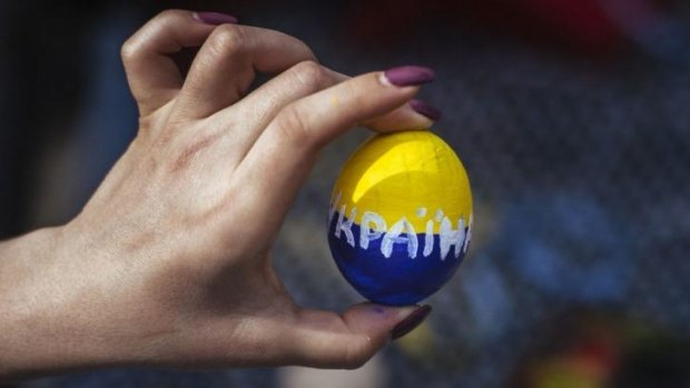 Fragile state: a woman holds an Easter egg painted with the Ukrainian national colours at a rally in the eastern city of Luhansk.