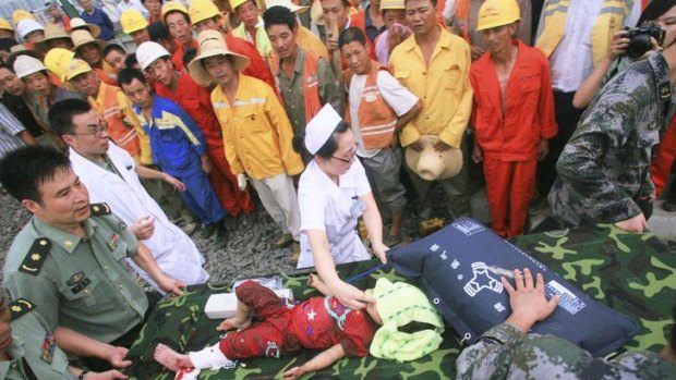 In this photo released by China's Xinhua news agency, rescuers carry an injured child to sent her to a hospital at the site where a high-speed train crash.