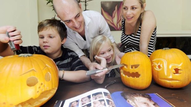 Juliet and Dan Toomey with Ashley, 10, and Lola, 5, carving pumpkins for Halloween in their Paddington home.
