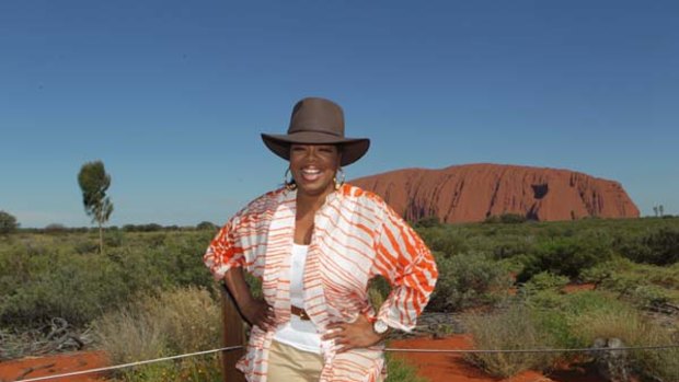"Hi guys" ... Oprah Winfrey poses for photographers before Uluru yesterday. "It strikes awe in your soul when you see it," she said.