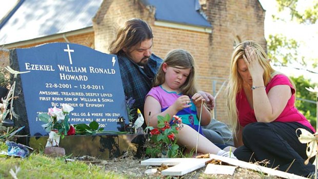 Sad and angry ... Sonja Howard joins her husband, Bill, and her daughter, Epiphony, at the grave of her son, Ezekiel.