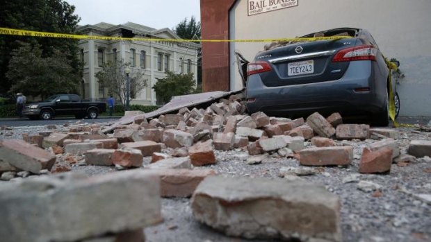 Bricks and fallen rubble cover a car following Sunday's earthquake in California.
