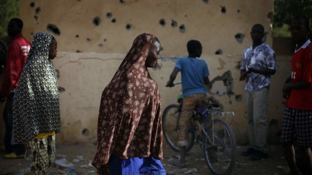 Shell shock ... Malian people mill through the heavily shelled police station in Gao. French and Malian government forces have regained control of this northern city, after Islamic fighters fought a prolonged battle.