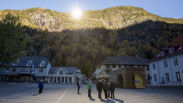 People gather on a spot in front of the town hall of Rjukan, Norway, where sunshine is reflected by three giant mirrors erected on the mountainside.
