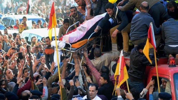 Egyptians carry the coffin of a victim killed from an explosion at a police headquarters  in the Nile Delta city of Mansoura.