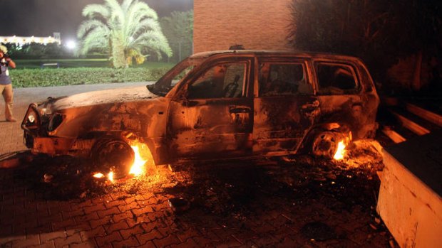 A vehicle sits smoldering in flames after being set on fire inside the US consulate compound in Benghazi.