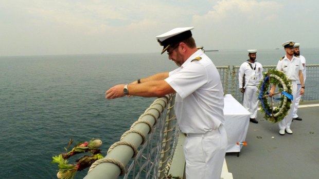 Ivan Ingham, captain of the present-day HMAS Perth, casts a wreath into the waters of the Sunda Strait to remember those who died while fighting the Imperial Japanese Navy on the first HMAS Perth in World War II.