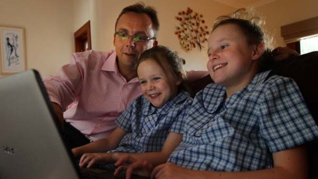 Richard Fechner with his daughters Evalyn, 7, left, and Georgie, 9, order their lunch online, and the web page, below.