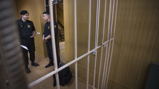 Show trial: Court officials stand beside an empty cage before the posthumous trial of Sergei Magnitsky