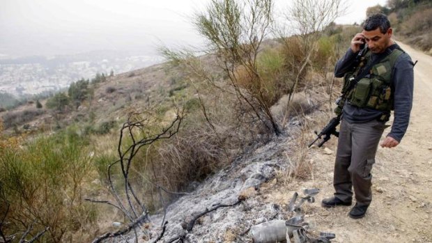 Northern Israel: A security coordinator inspects the remains of a rocket fired from Lebanon near the town of Kiryat Shmona.