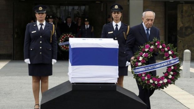 Israeli President Shimon Peres lays a wreath by the coffin of former prime minister Ariel Sharon at the Knesset.
