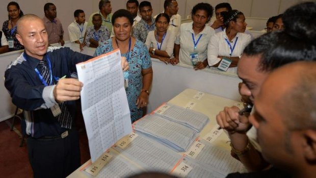 An election supervisor holds up votes for scrutineers during Fiji's general election.