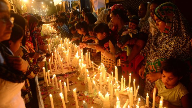 Pakistani Christian and activists of the Muttahida Qaumi Movement light candles for the victims of a suicide bombing that targeted a church in Karachi on September 23, 2013. 