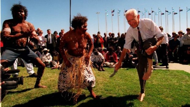 Former independent Tasmanian senator Brian Harradine removes his shoes and socks to dance with members of Cape York's Wik people outside Parliament House in Canberra in 1998.