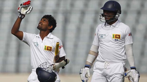 Sri Lanka's Kaushal Silva gestures to the heavens on reaching his century as teammate Kumar Sangakkara watches, on the second day of the first Test against Bangladesh.