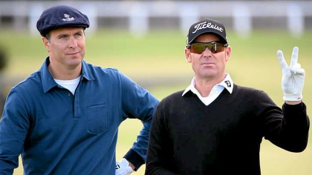 Shane Warne (R), with fellow cricketer Michael Vaughan, has bettered par at St Andrews.
