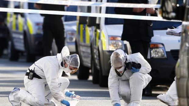 Forensic officers collect evidence at the scene where two female police officers were killed.