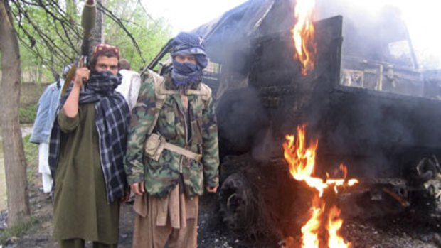 Inferno  ... Taliban insurgents pose in front of a burning German military vehicle in Kunduz province.