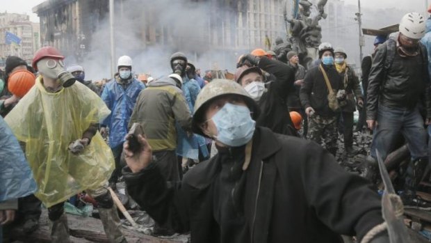 Anti-government protesters throw stones during clashes with riot police in Kiev.