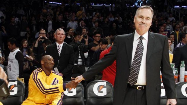 Los Angeles Lakers head coach Mike D'Antoni shakes hands with Kobe Bryant (L) before making his coaching debut with the Lakers in their game against the Brooklyn Nets in Los Angeles.