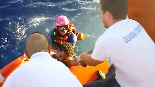 Safe at last: The Italian coastguard rescues one of the migrants off the coast of  Lampedusa on Thursday.